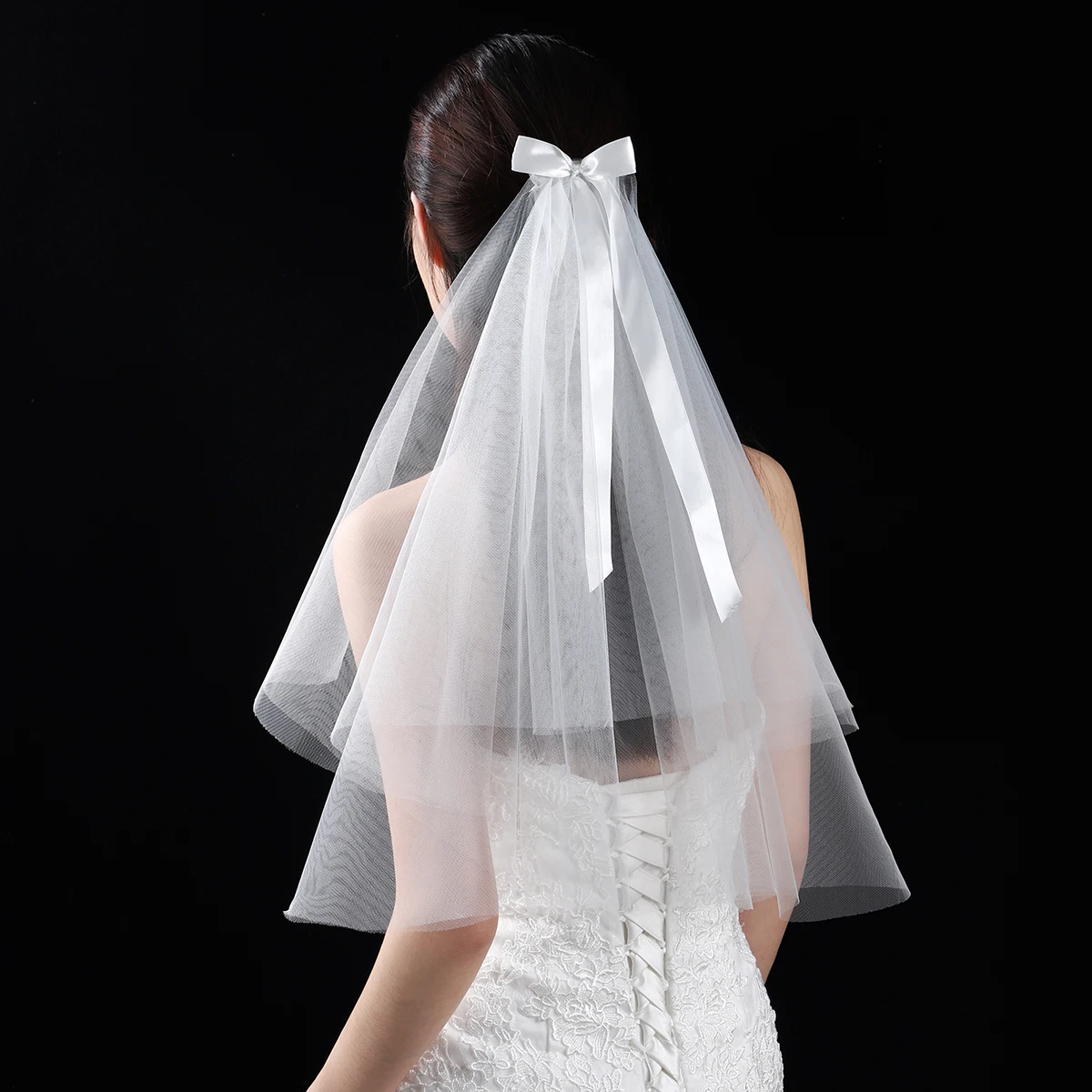 A white elegant bridal veil adorned with a simple bow, waist length veil suitable for women's weddings