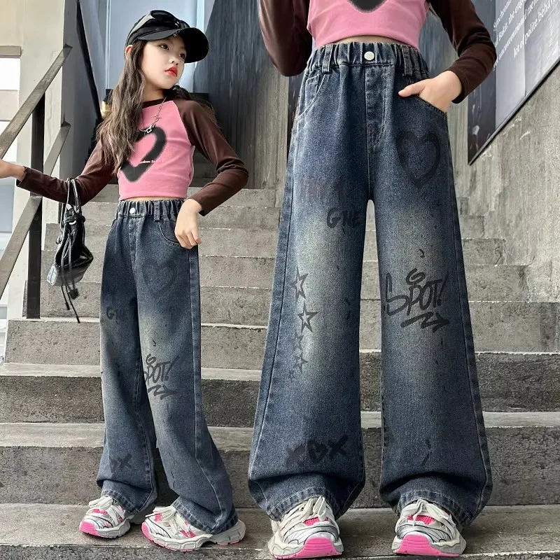 The wide leg jeans for girls are designed with graffiti patterns, showcasing a deep street chic style while maintaining a slim a