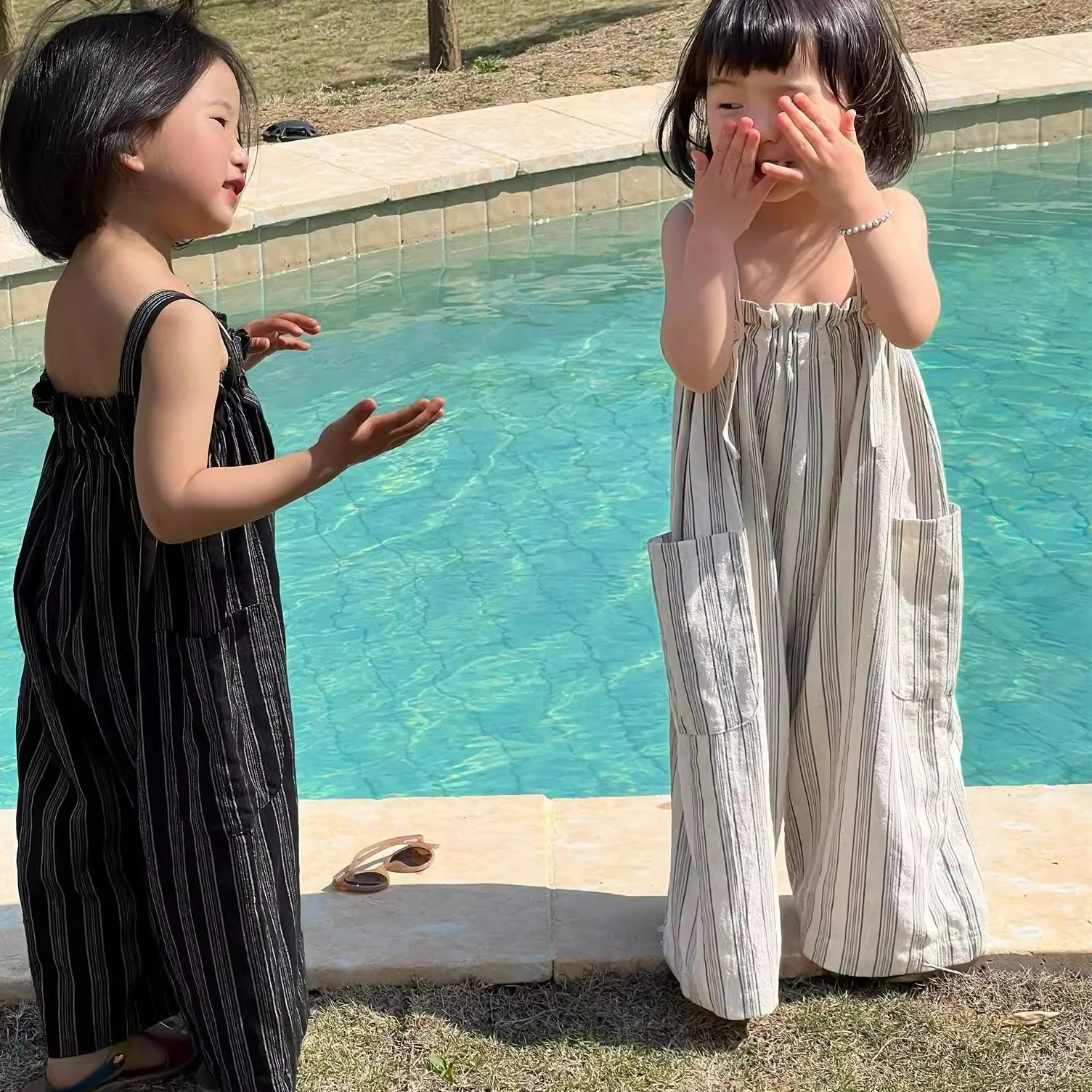 الفتيات العمودي مخطط ثنائي الجيوب بذلة الأطفال السراويل 2025 الزي الصيفي ملابس الأطفال اليابانية والكورية الجديدة