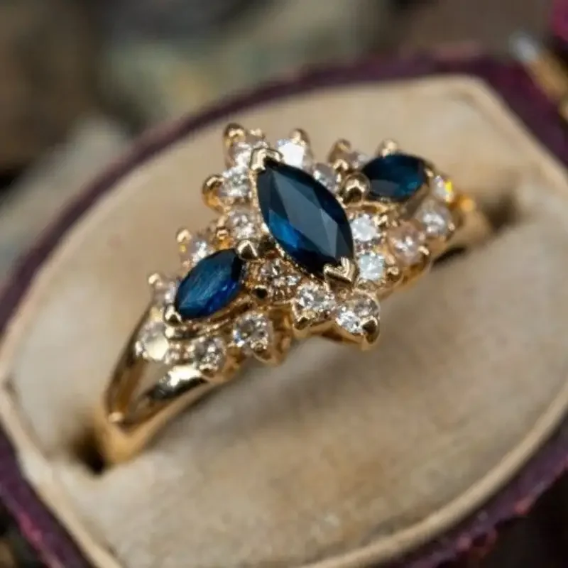 Huitan Edler Damenring in Goldfarbe, für Hochzeit, Verlobung, elegantes Zubehör, eingelegt mit glänzendem blauem Marquise-CZ, bezaubernder Damenschmuck