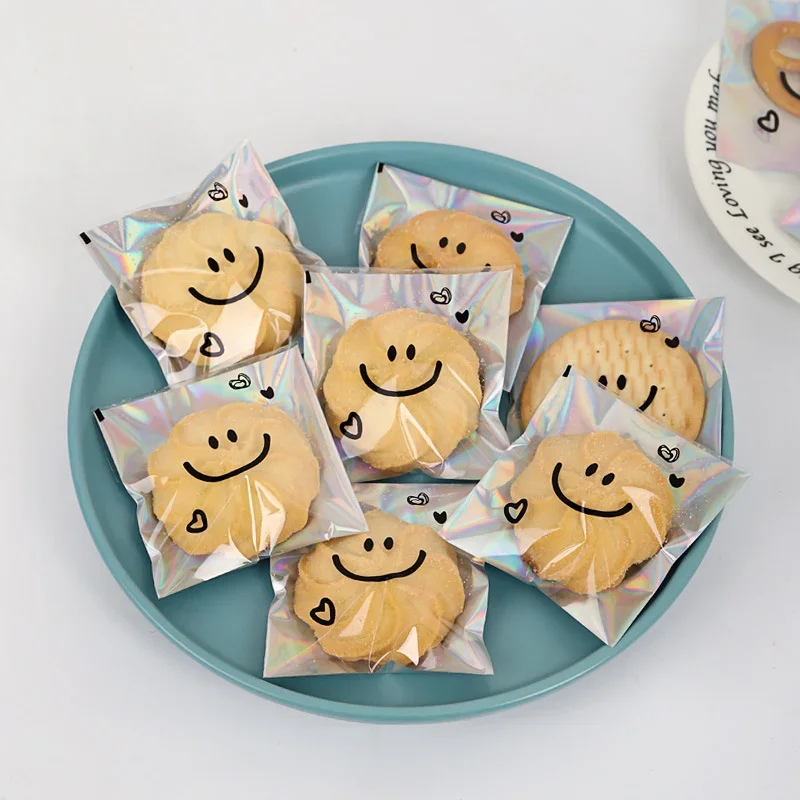 100pcs Cookie Packaging Bags Cute Smiling Face Self-adhesive Laser Transparent Snowflake Crisp Cupcake Cake Biscuit Macaron Bag