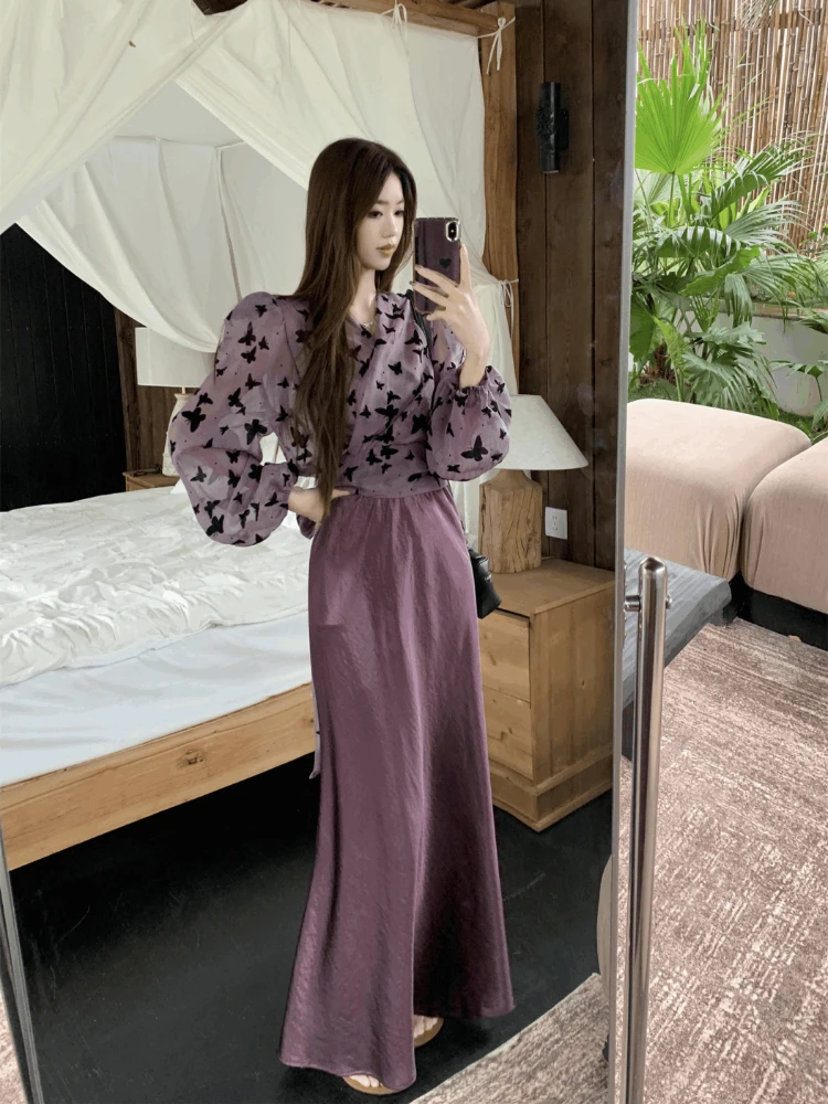 

Фиолетовый топ с принтом и завязками, длинными рукавами и юбка миди с высокой талией – комплект из двух предметов. Модный женский костюм Лето 2026.