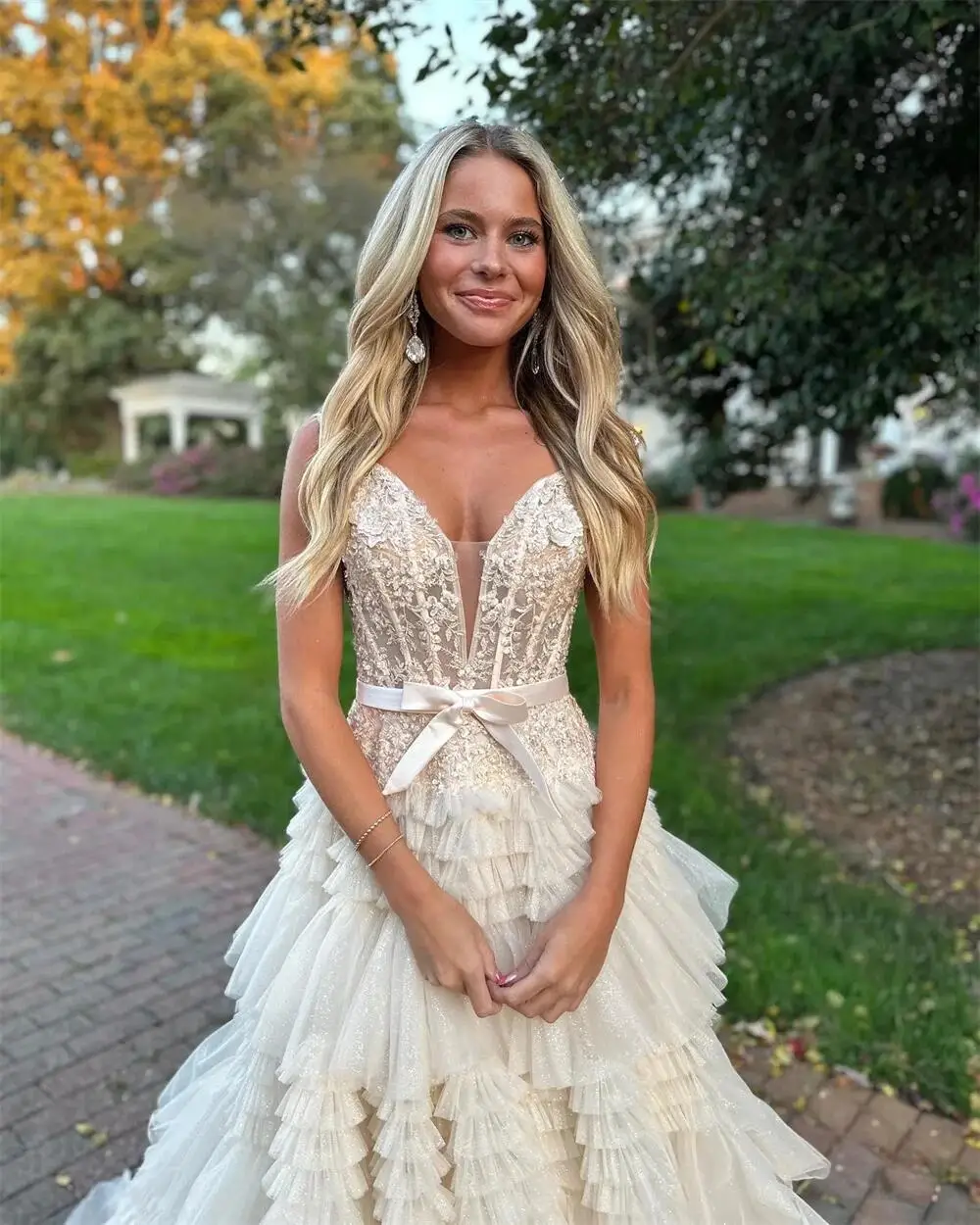 ที่กําหนดเองคุณภาพสูงชุดแต่งงานสีขาวริ้วรอย V คอแขนกุดความยาวกวาดรถไฟ Bow Tie Backless Tulle ดอกไม้