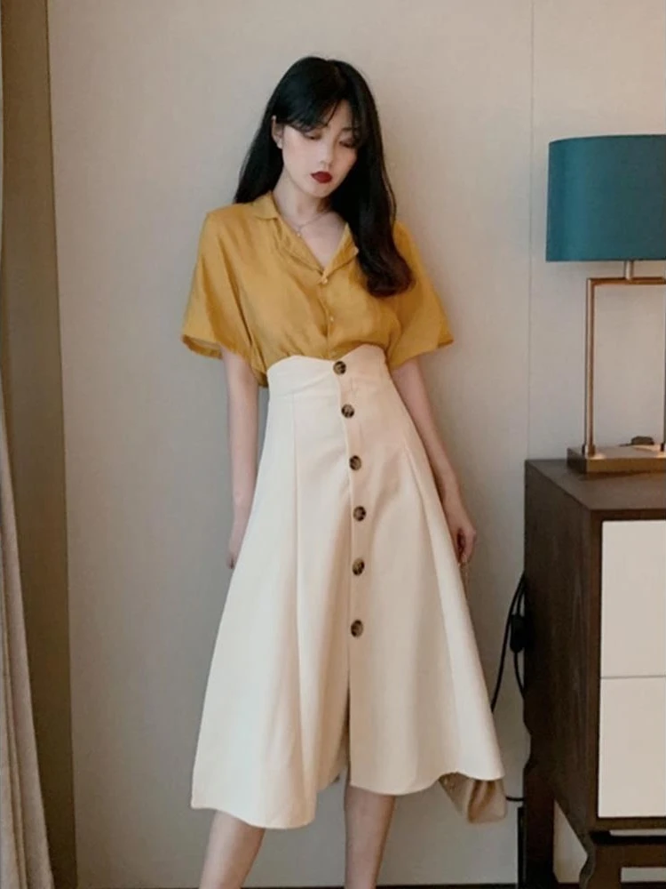 

Летний комплект 2026: Новинка в корейском стиле – повседневный элегантный женский костюм для студенток: рубашка с коротким рукавом на одной пуговице и юбка миди с завышенной талией