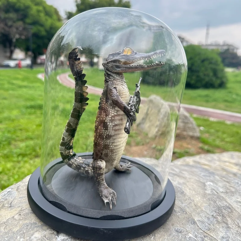 Glass covered crocodile specimen ornament, tennis themed decoration, hand violin and submachine gun, glass display cover, black
