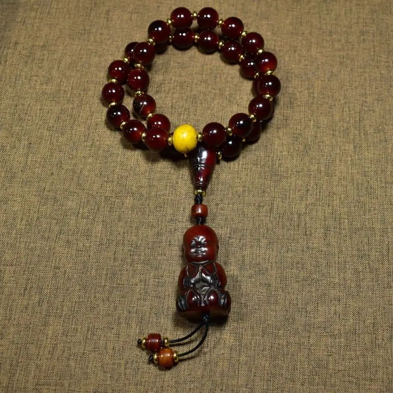 Tibetan-style beads paired with a horn boy figure holding them   Weighs 102 grams