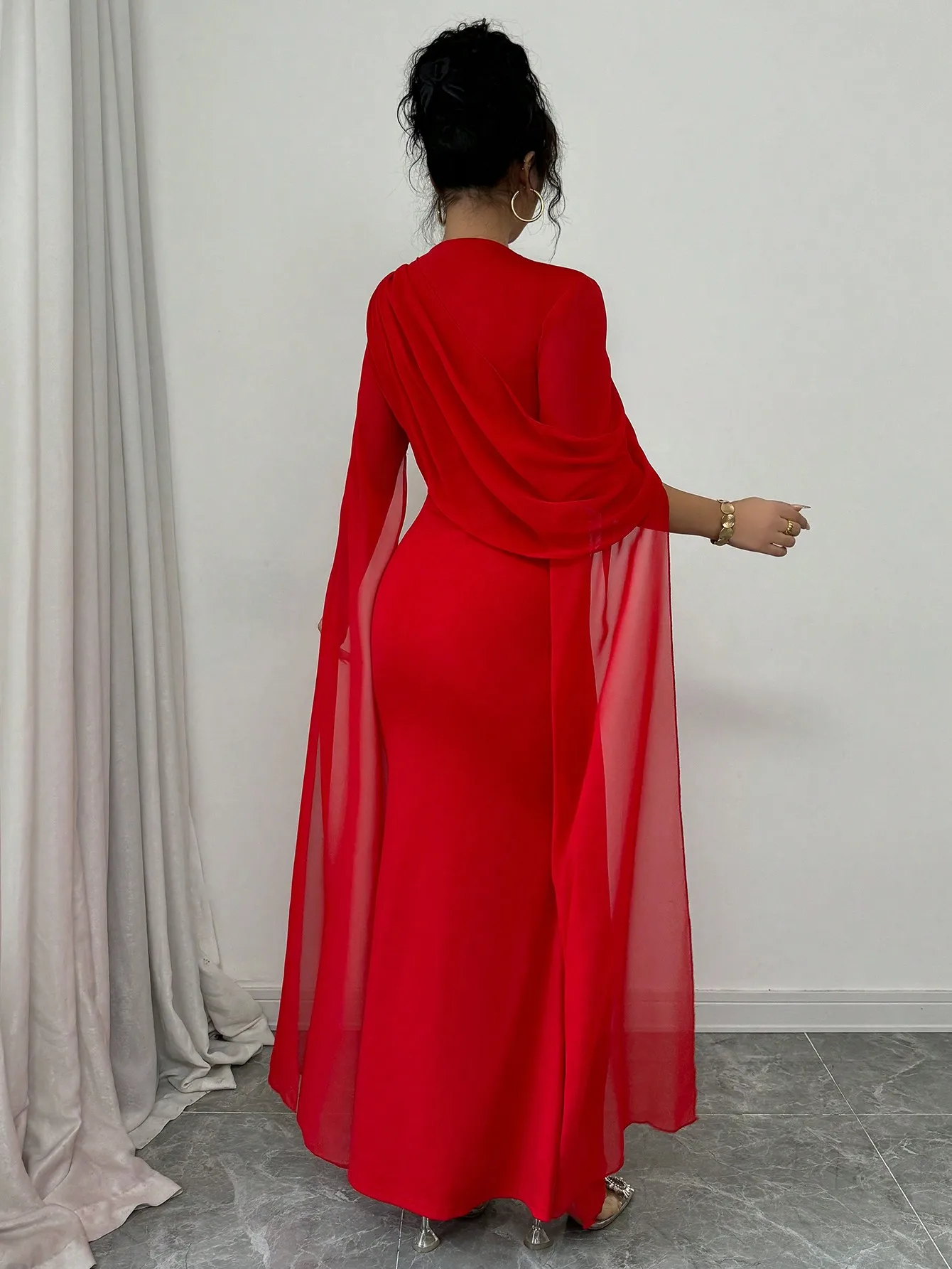 Robe longue asymétrique rouge avec manches cape transparentes et détails plissés