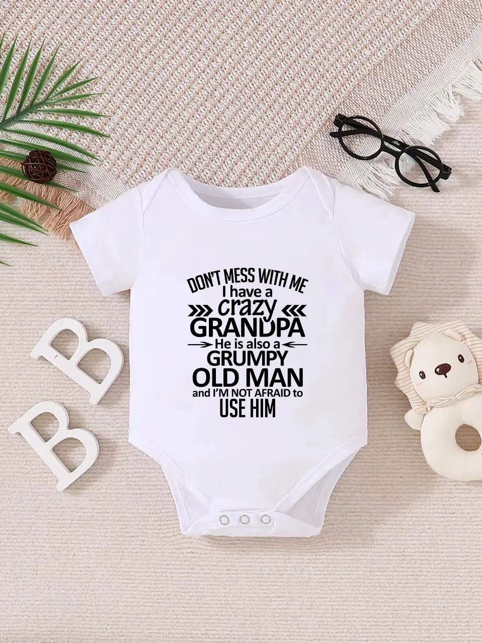 Playful letter-printed baby short-sleeve triangle bodysuit. Button closure for easy dressing