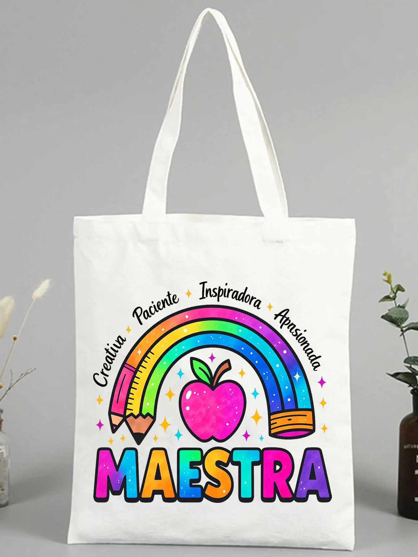 Teacher's canvas tote bag with rainbow, apple and pencil graphics, perfect for school use and daily teaching