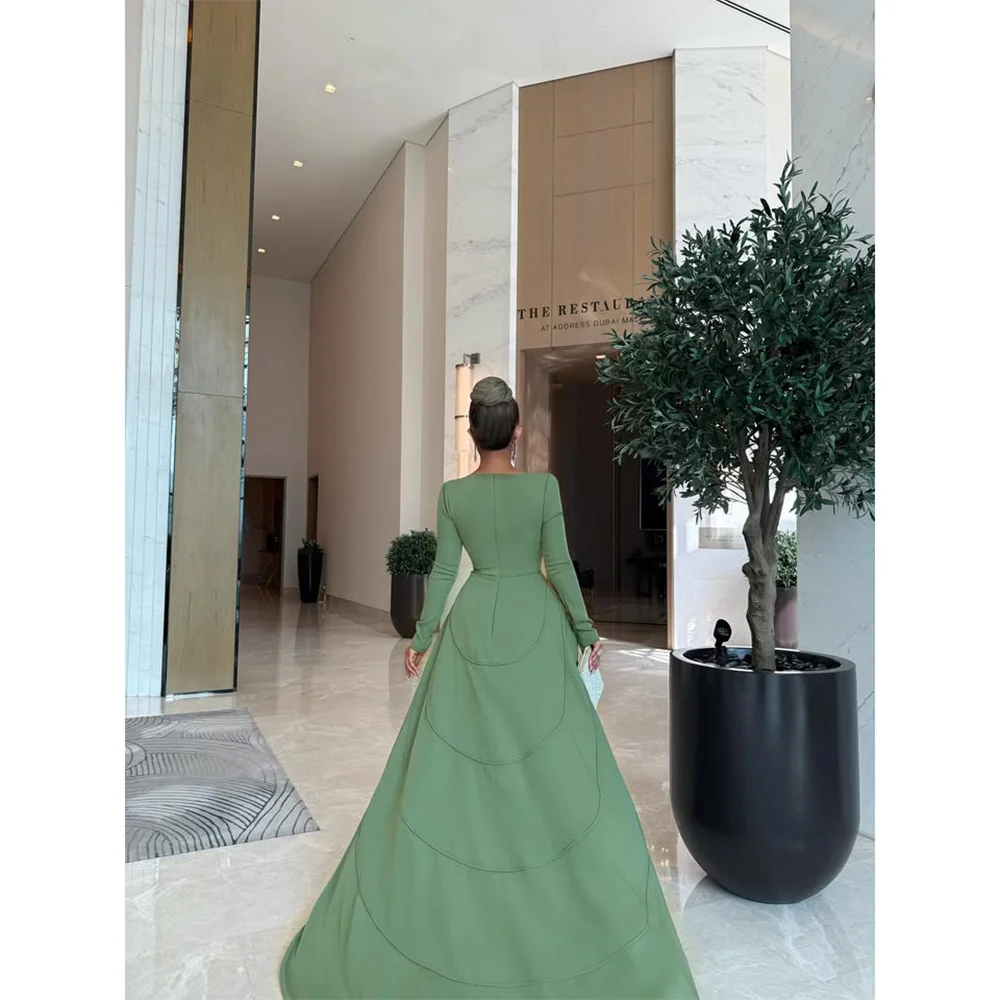 ชุดราตรีสีเขียวแบบสั่งตัด คอทรงโอ แขนยาว ทรงเมอร์เมด กระโปรงยาวทรงทรัมเป็ตจีบระบาย ชุดราตรีออกงานปี 2025