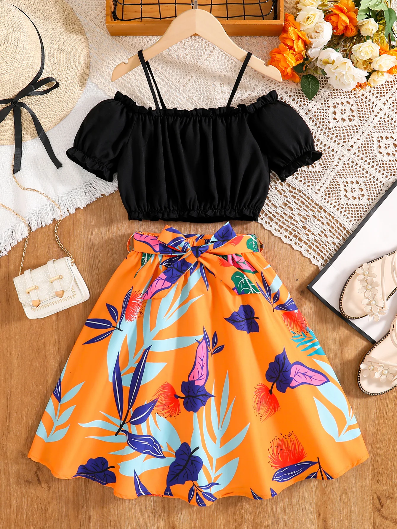 🔥   Mädchen-Sommerurlaubs-Set im Zweiteiler-Stil 🔥     Schwarzes schulterfreies Crop-Top mit Puffärmeln + leuchtend orangefarbener Rock mit tropischem Print und hoher Taille