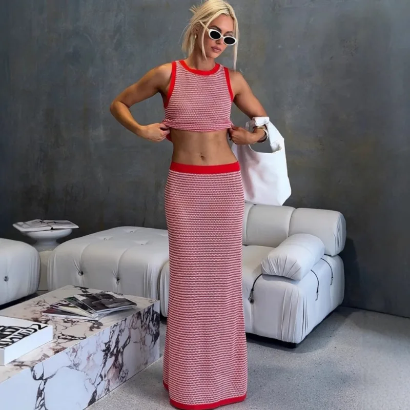 

Вязаный комплект из двух предметов: женский вязаный жилет без рукавов в полоску и облегающее длинное платье. Модный сексуальный комплект.