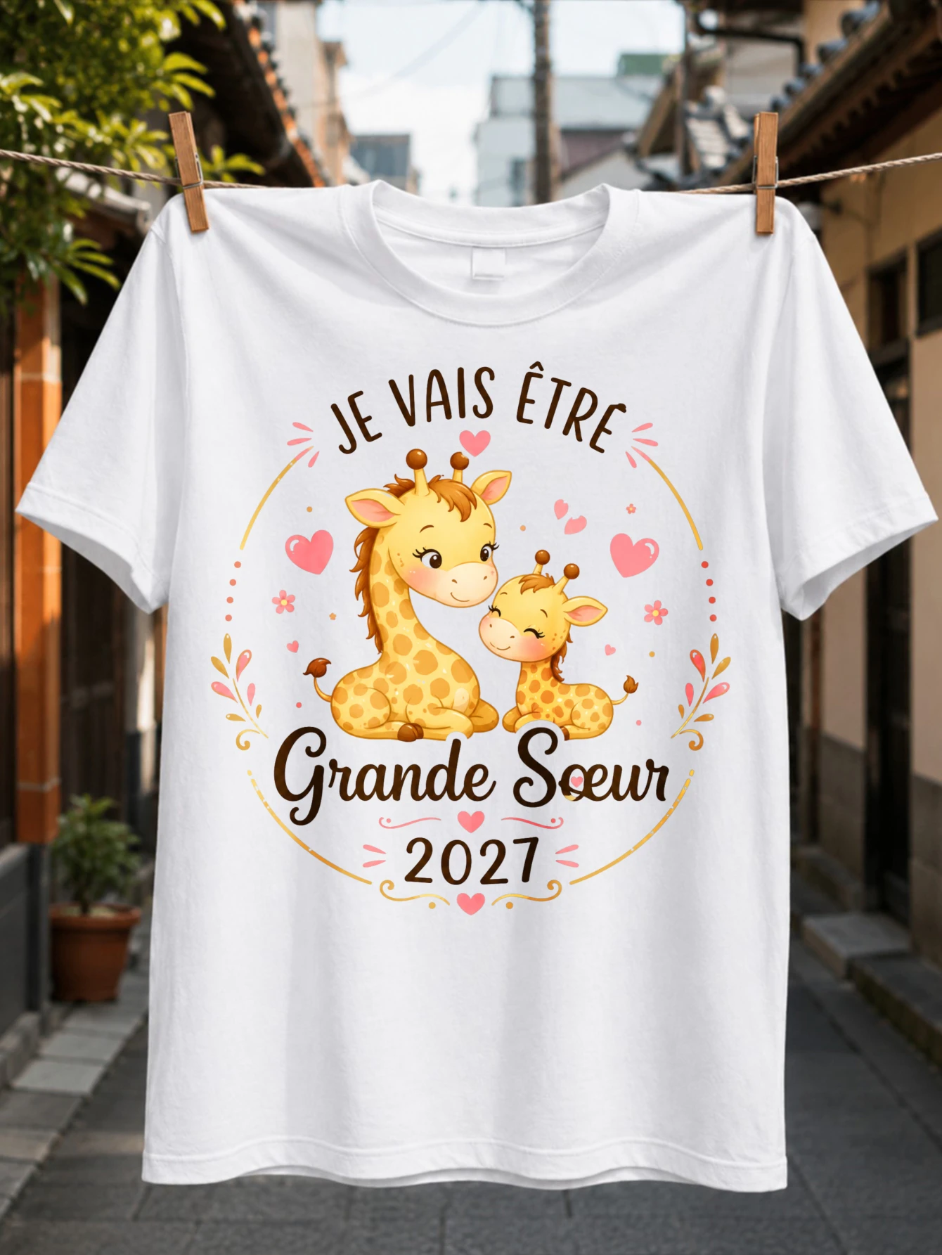 T-shirt unisexe « JE VAIS ÊTRE GRANDE SOEUR 2027 » avec deux girafes mignonnes, fleurs et cœurs