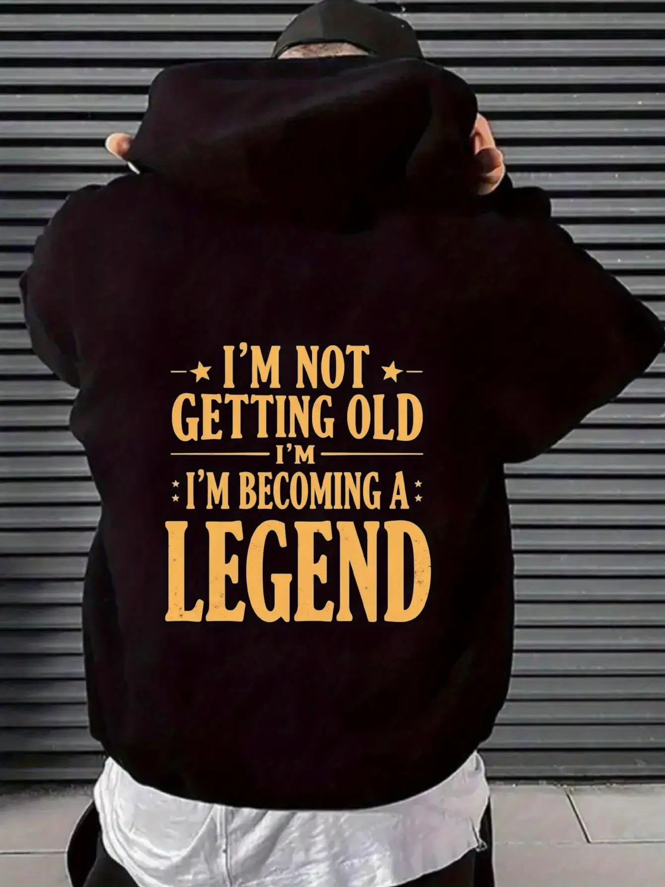 هوديي أسود للرجال مع "لست عجوزًا، لقد أصبح أسطورة" باللون الذهبي - بلوفر بنمط بيان جريء، فضفاض Ca
