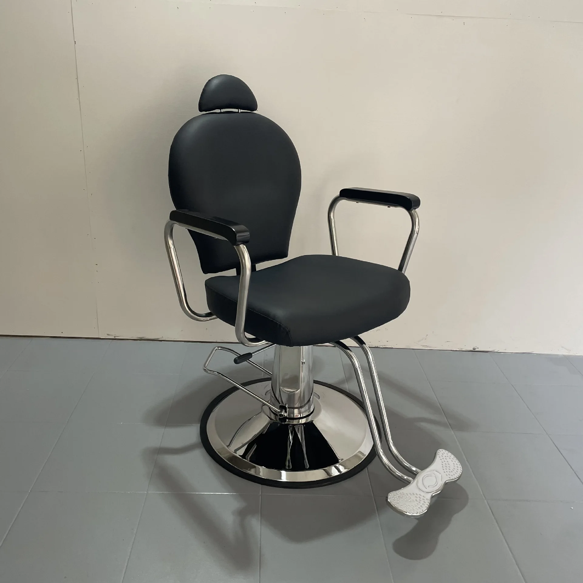 Sillón de barbero reclinable con reposabrazos de acero inoxidable, cojín elevable y extraíble, especial para barberías y salones de belleza.