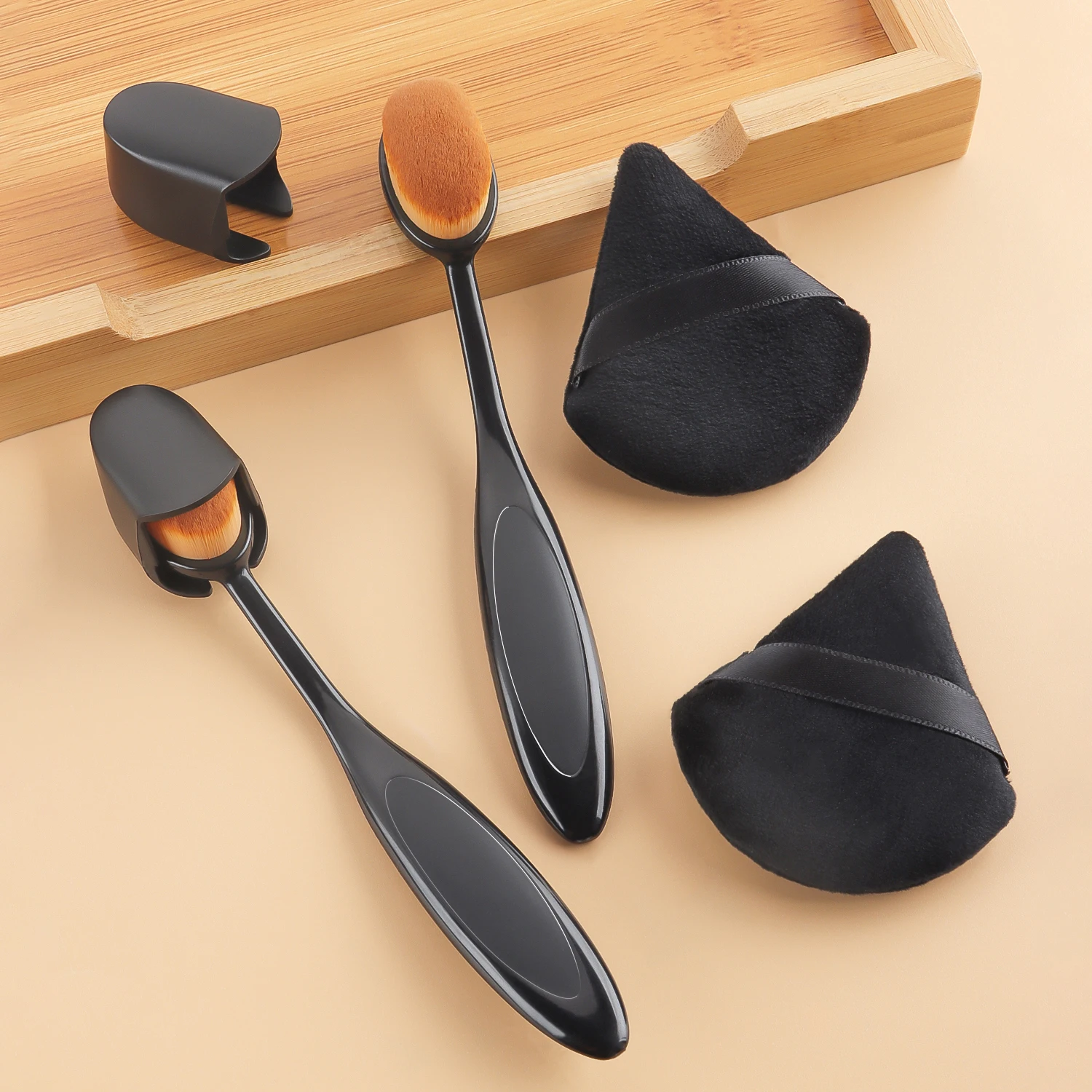 2 pincéis ovais para aplicar base, com capa + 2 esponjas triangulares pretas de veludo para aplicar base, pó solto e blush.