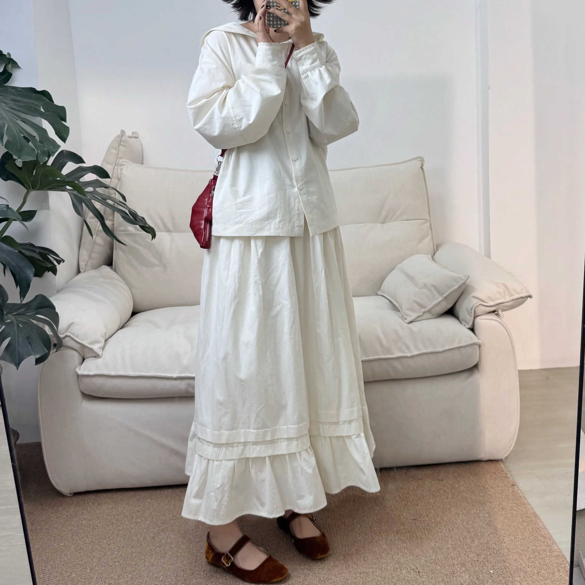 

Комплект: женская повседневная блузка с круглым вырезом и длинными рукавами, а также макси-юбка свободного кроя из конопляного хлопка с воротником-стойкой.