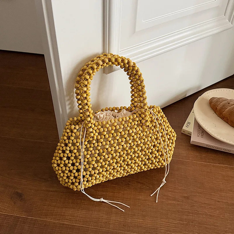 

2026 Handmade Beaded Woven Handbag Hollow Out Design Women's Simple Street Trend Handheld Bag Vacation Solid Color Beach Bag