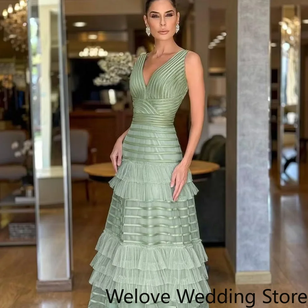 Sage Green Formal Evening Gown Featuring a deep V-neckline, structured pleated bodice, and voluminous tiered ruffle tulle skirt