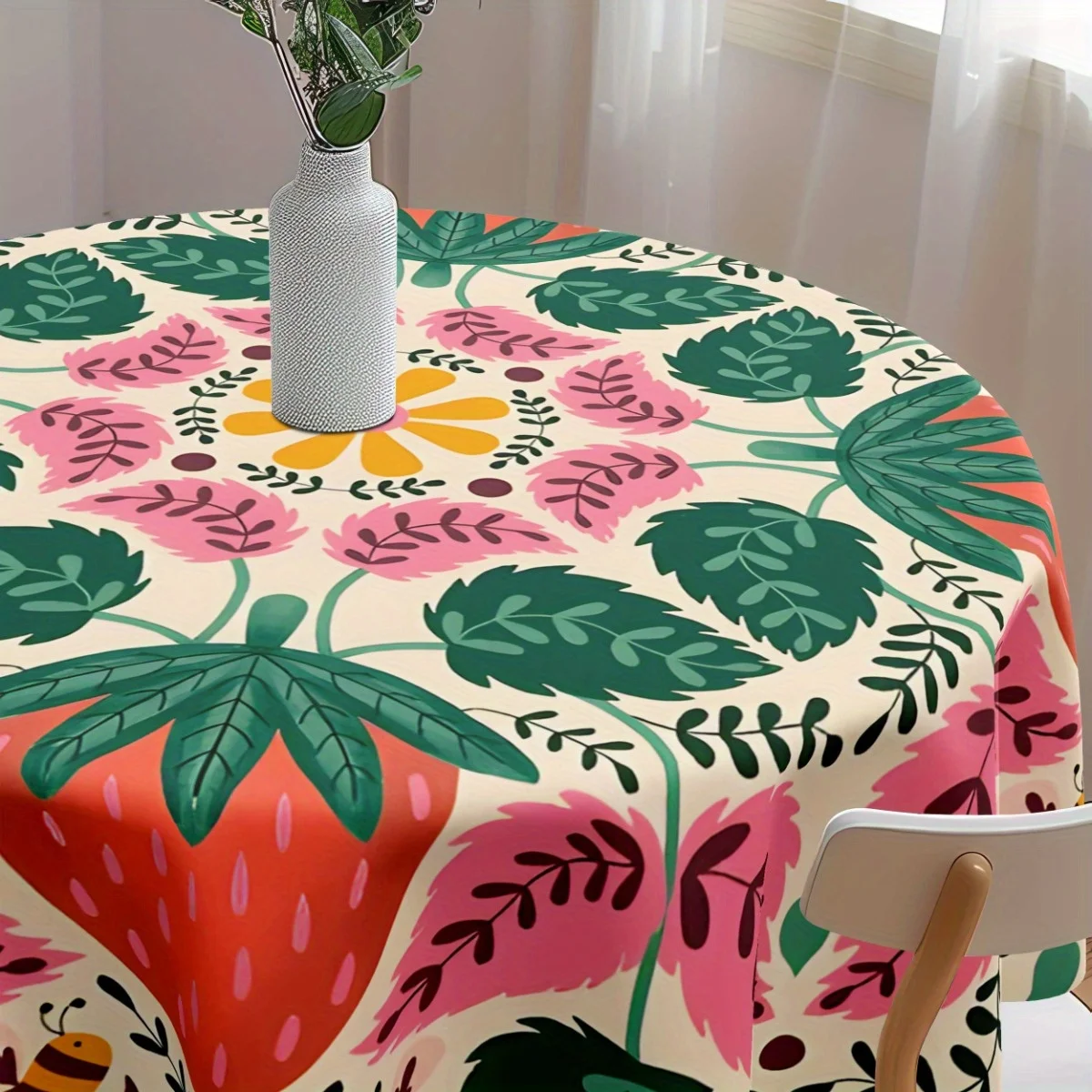 A bohemian strawberry and floral tablecloth with vibrant pink, green and orange motifs and a round design