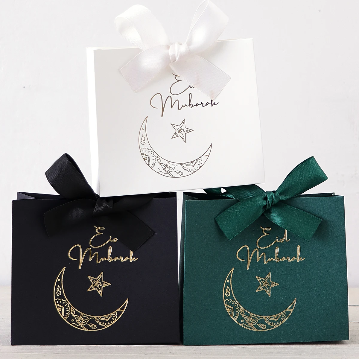 5 Exquisite and Compact Eid Gift Boxes, Available in Elegant Black, Luxurious Green, and Pure White, Decorated with Delicate Gold and Silver Star and Moon Patterns, and Adorned with Luxurious Gold and Silver Ribbons. These Gift Boxes Are Made from High-Quality Materials, Making Them Ideal for Storing Candies, Chocolates, and Small Gifts, and Are Also Great Packaging for Special Occasions.