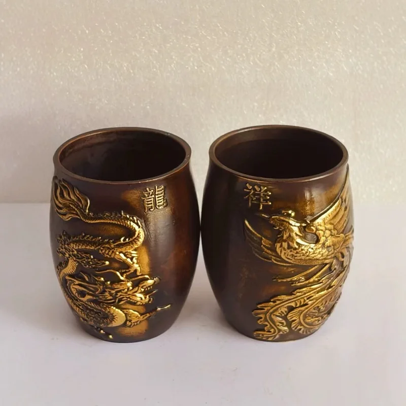 A pair of antique-style copper dragon phoenix wine cups, with a neat shape, a warm patina, and a smooth finish, serving as d