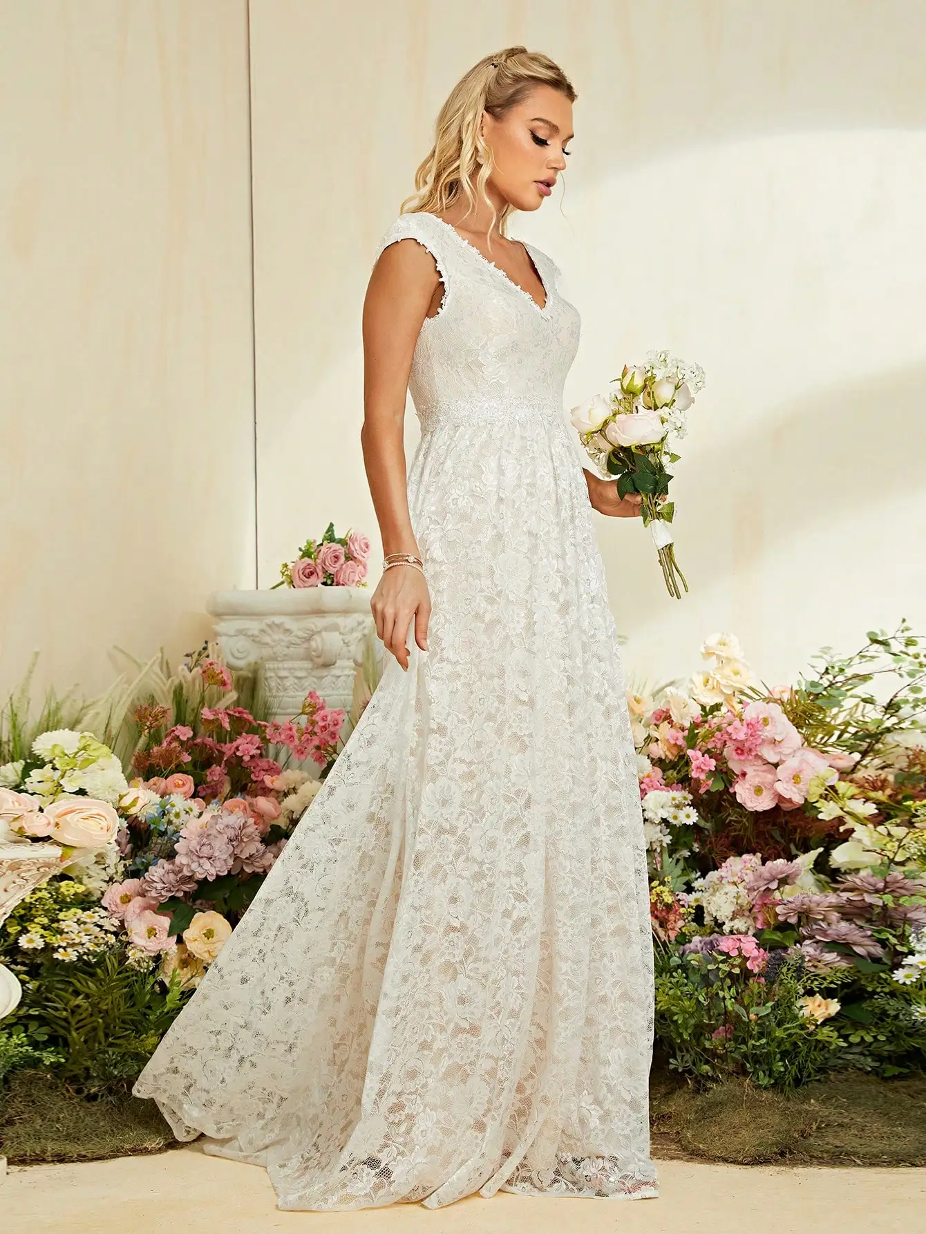 Suknia ślubna z dekoltem w kształcie litery V, zdobiona cekinami i koronką.