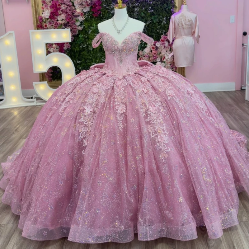 

Pink Shiny Ball Gown Quinceanera Dresses 2026 Applique Flower Beading Crystal Bow Corset Tull Off Shoulder Sweet 16 Dress Vesti