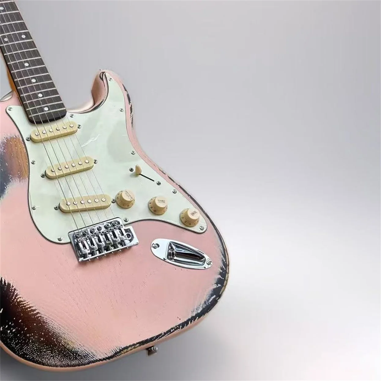 Heavy relic light pink electric guitar inlaid with vibrato bridge striking bar retro tuner chrome hardware