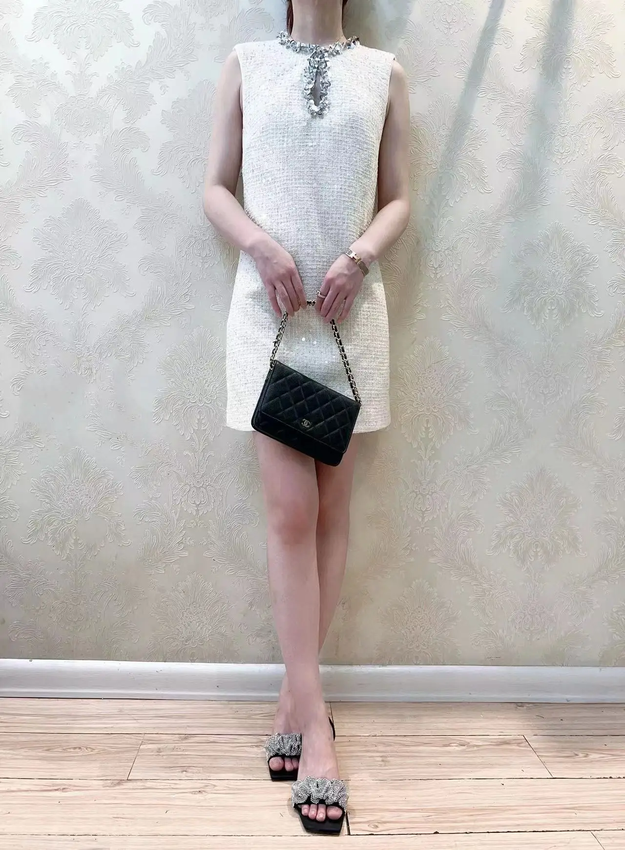 エレガントなアイボリーのスパンコールが輝く、Aラインの透かし彫りデザインのノースリーブガウン。女性用ポリエステル生地のパーティードレス。2024年春コレクション。