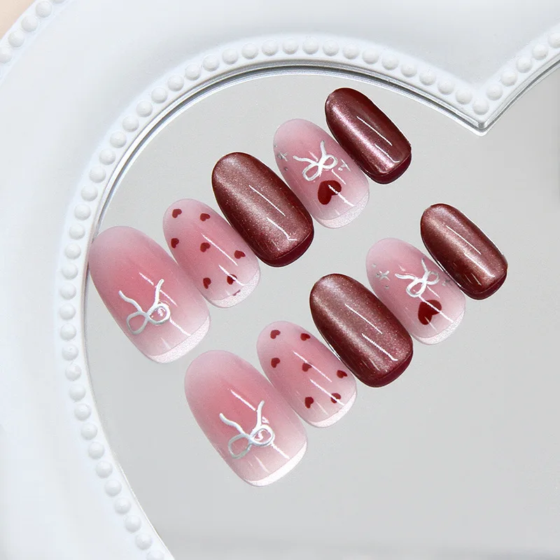24 Stück handgefertigte kurze runde Nägel. Transparentes Rosa mit rötlich-braunem Katzenaugen-Effekt, silbernen Schleifen und kleinen roten Punkten. Wiederverwendbar, süßes Design für – Detail 3