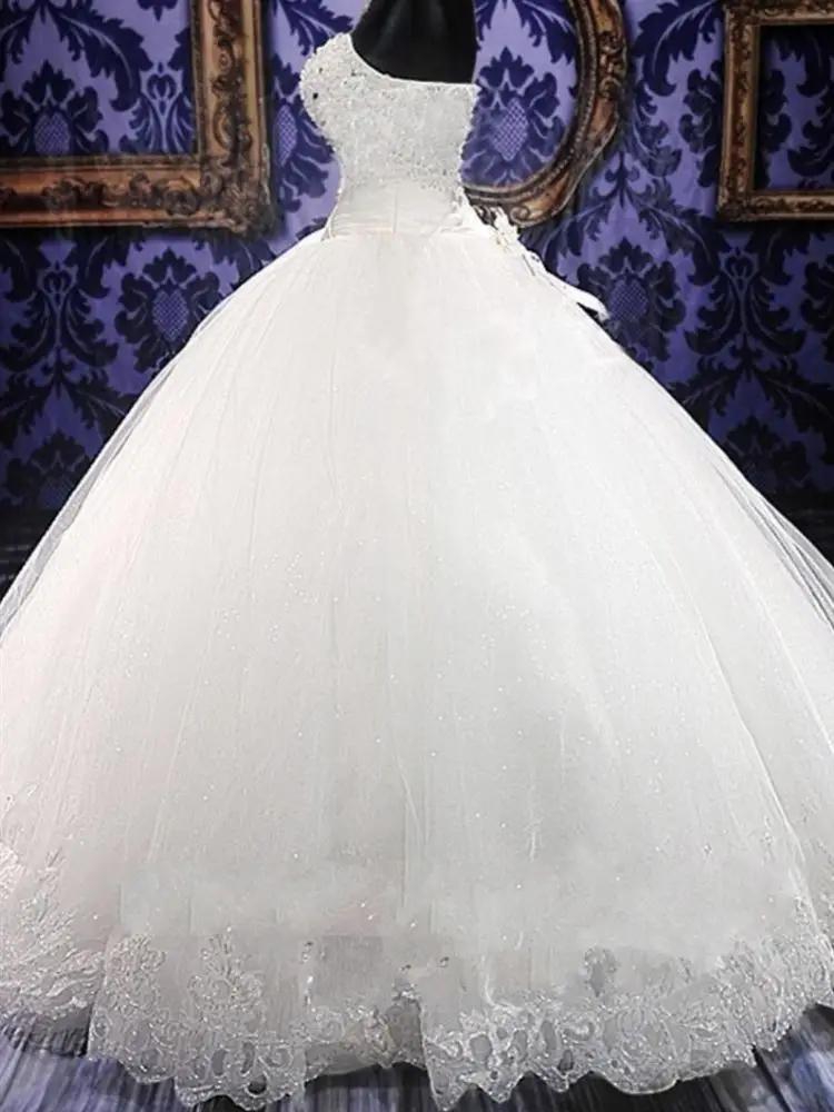 فستان زفاف بسيط كبير الحجم بدون حمالات طويل يصل للأرض باللون الأبيض لفصلي الخريف والشتاء بتصميم أنيق وبسيط