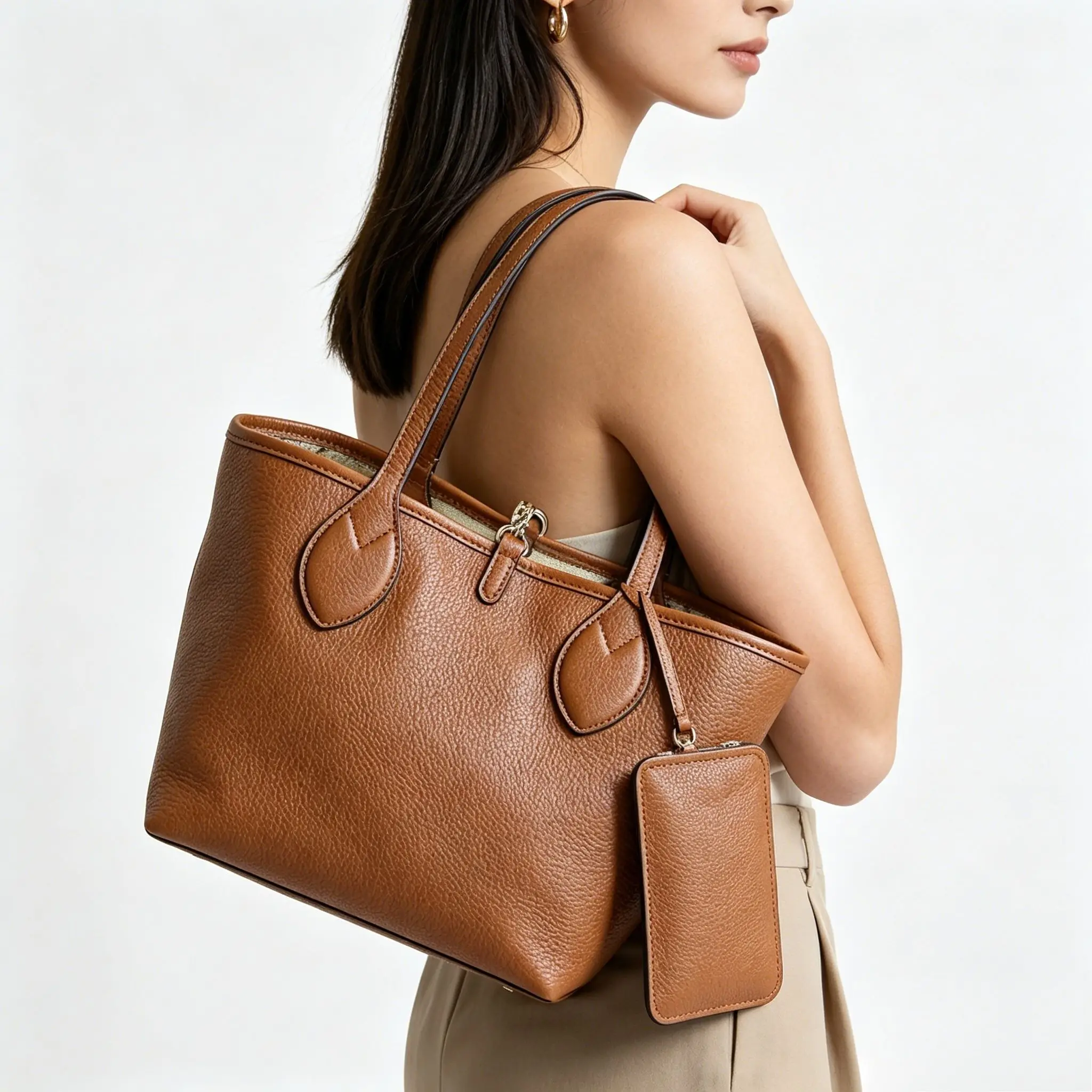 

Tan pebbled leather tote bag with a detachable matching pouch, spacious interior, and dual top handles.