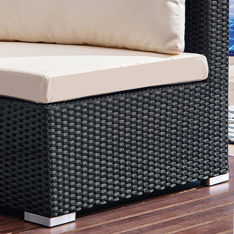 Semicircular rattan sofa on a patio with plants