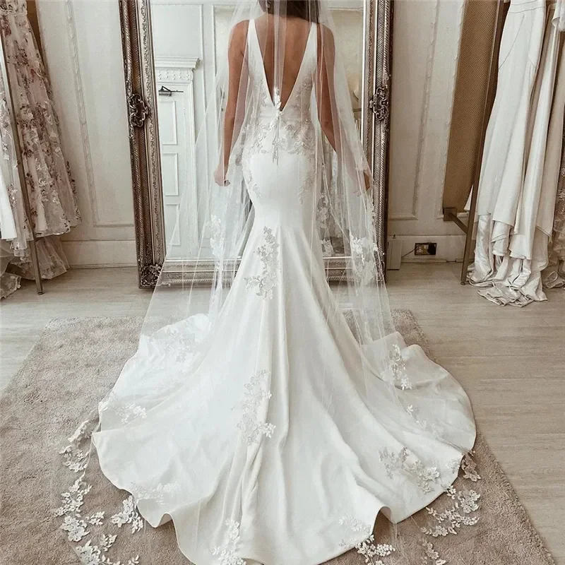 Abito da sposa glamour a sirena senza schienale Corte dei treni Applique in pizzo Abiti da sposa applique senza maniche con scollo a V profondo Personalizzati