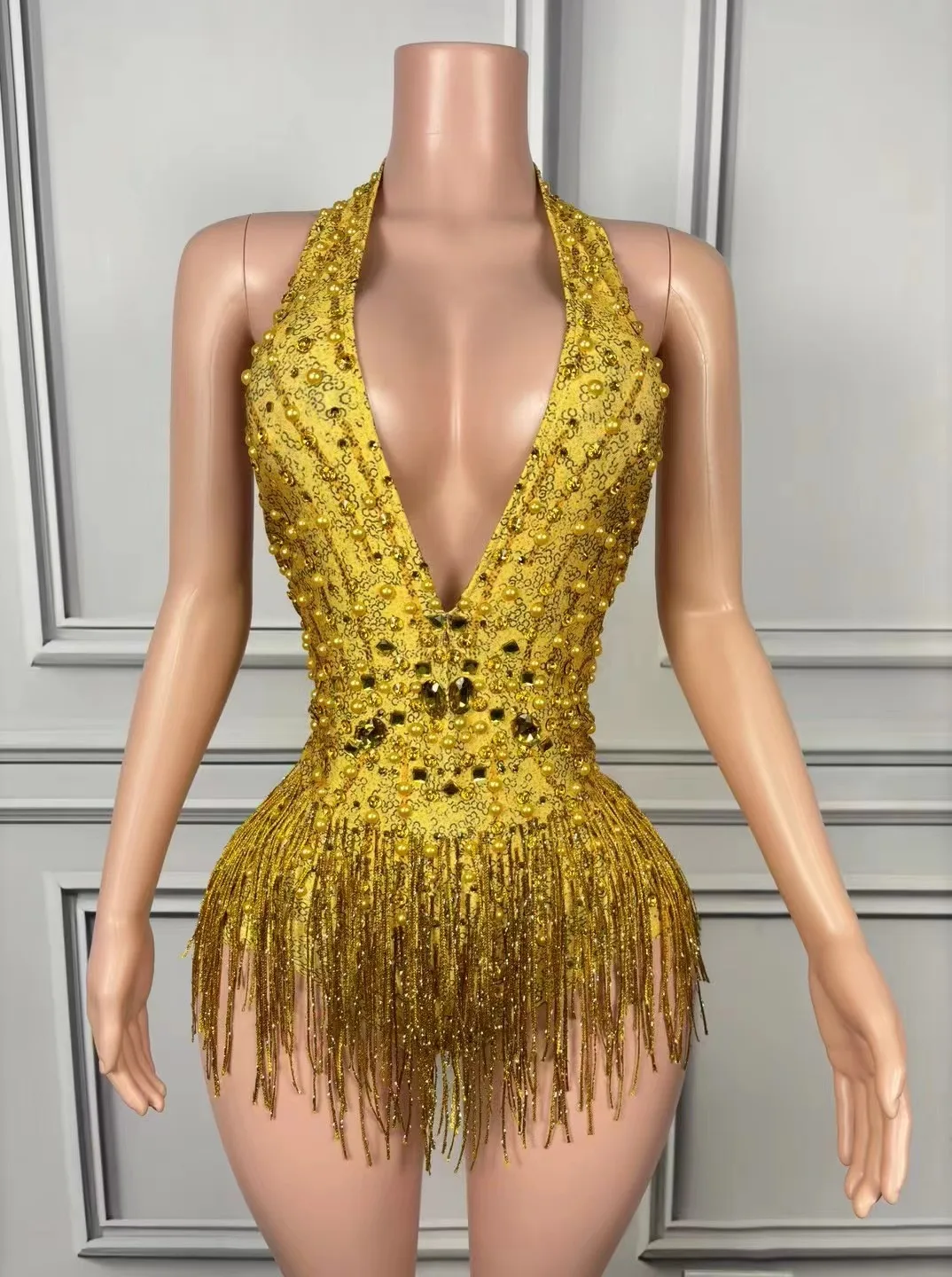 Seksowny kombinezon bez pleców z głębokim dekoltem w kształcie litery V, zdobiony cyrkoniami, idealny na zawody tańca latynoamerykańskiego w stylu standardowym.