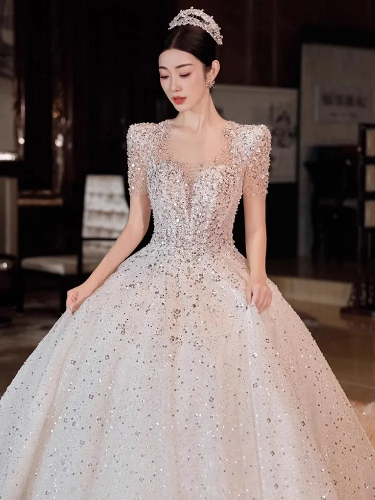 فستان زفاف أنيق بأكمام قصيرة، ثوب فاخر بذيل للعرائس، تطريز ثقيل، تصميم صدرية مع ذيل طويل، قماش كريستالي