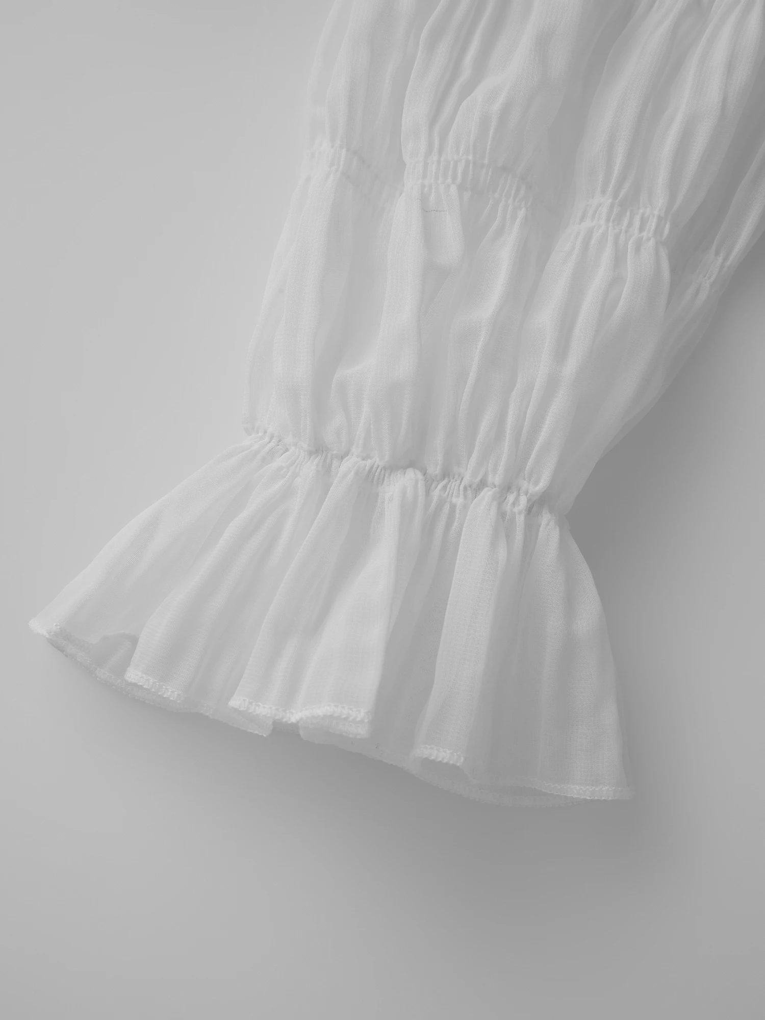 بلوزة أنيقة مزينة بالدانتيل مكشوفة الكتف بأكمام جرس وتفاصيل مطرزة بالزهور لفصلي الربيع والصيف