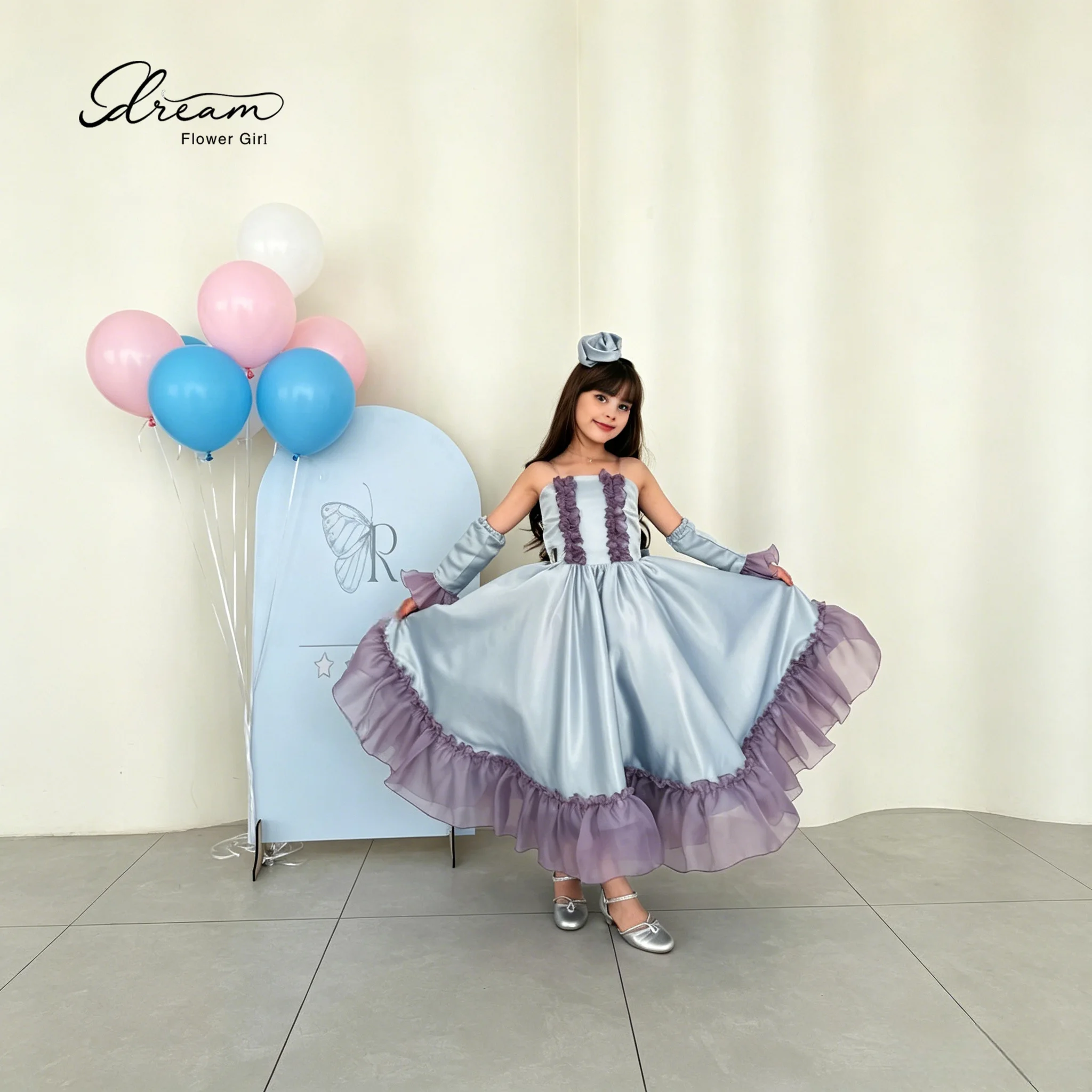 An elegant young lady's strapless formal ball gown, with a fluffy skirt and decorated with purple bows.