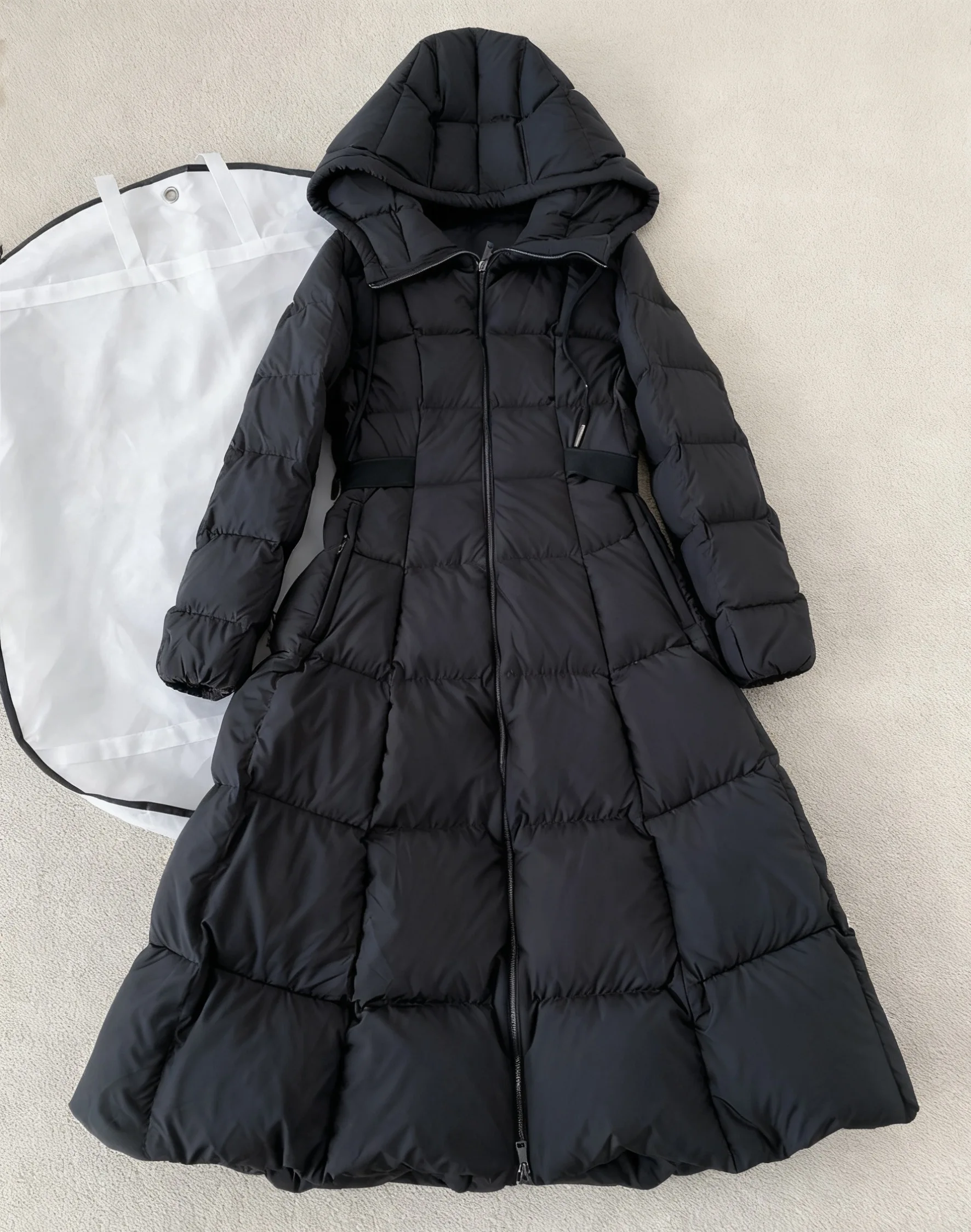 Długa czarna kurtka puchowa damska z kapturem, regulowanym sznurkiem w pasie, ocieplana, pikowana, pełnowymiarowa kurtka puchowa na zimę 2025.