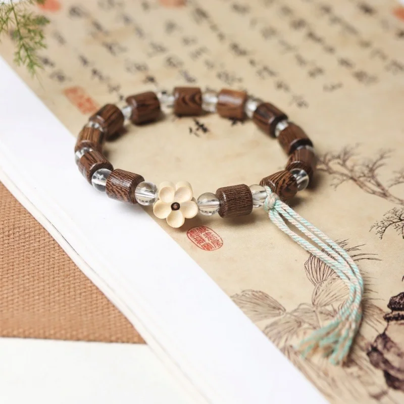 

Chicken wing wood barrel beads paired with small floral accessories in a single-loop bracelet design are versatile in style