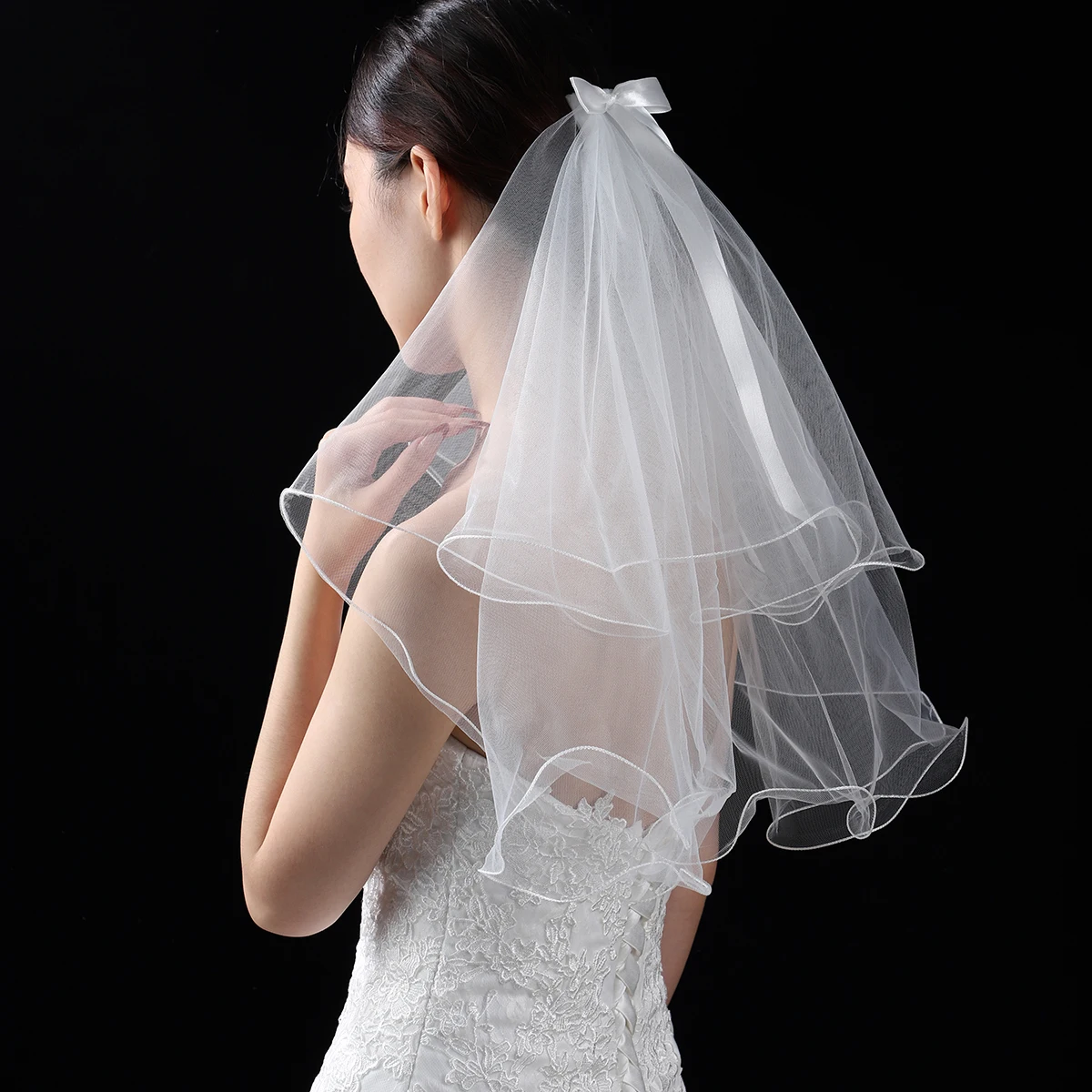 A white elegant bridal veil adorned with a simple bow, waist length veil suitable for women's weddings