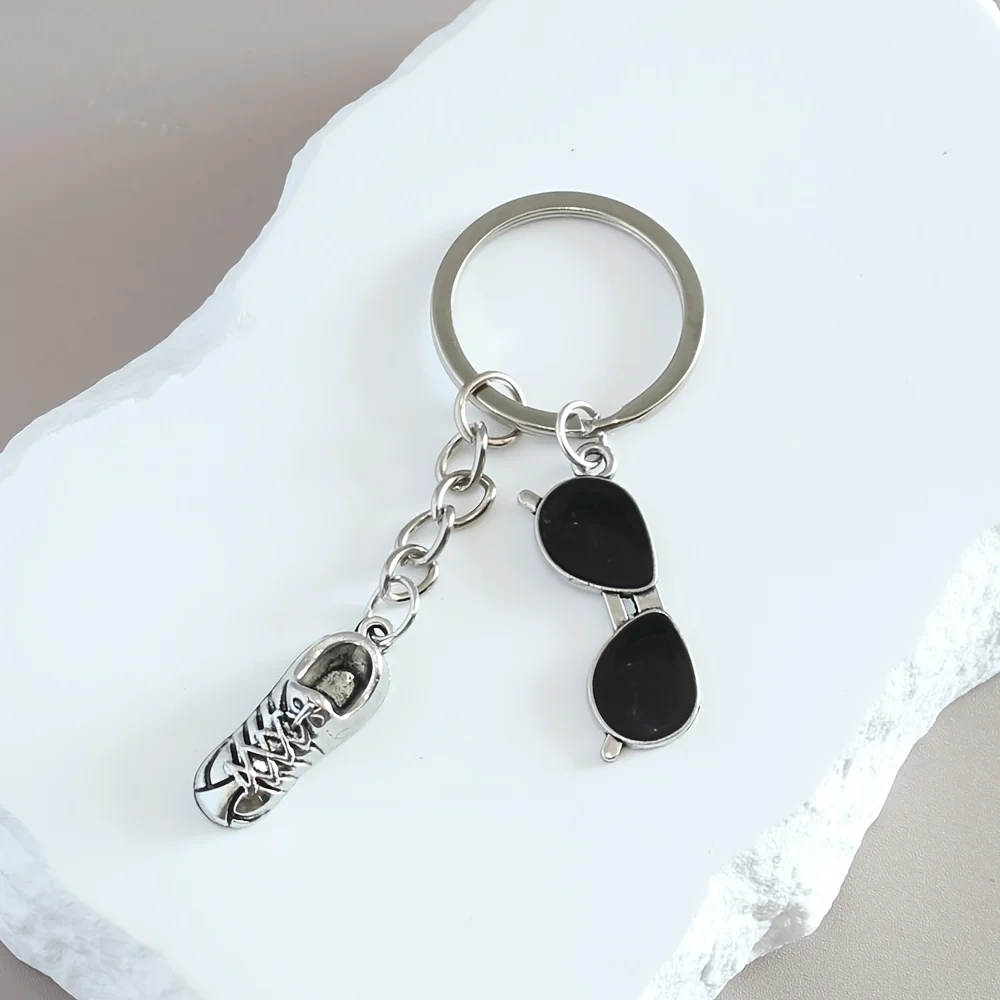A Sweet And Stylish Keychain Featuring Silvery Shoes And Small Glasses, Perfect As a Gift Or Accessory for Bags Wallets And Key