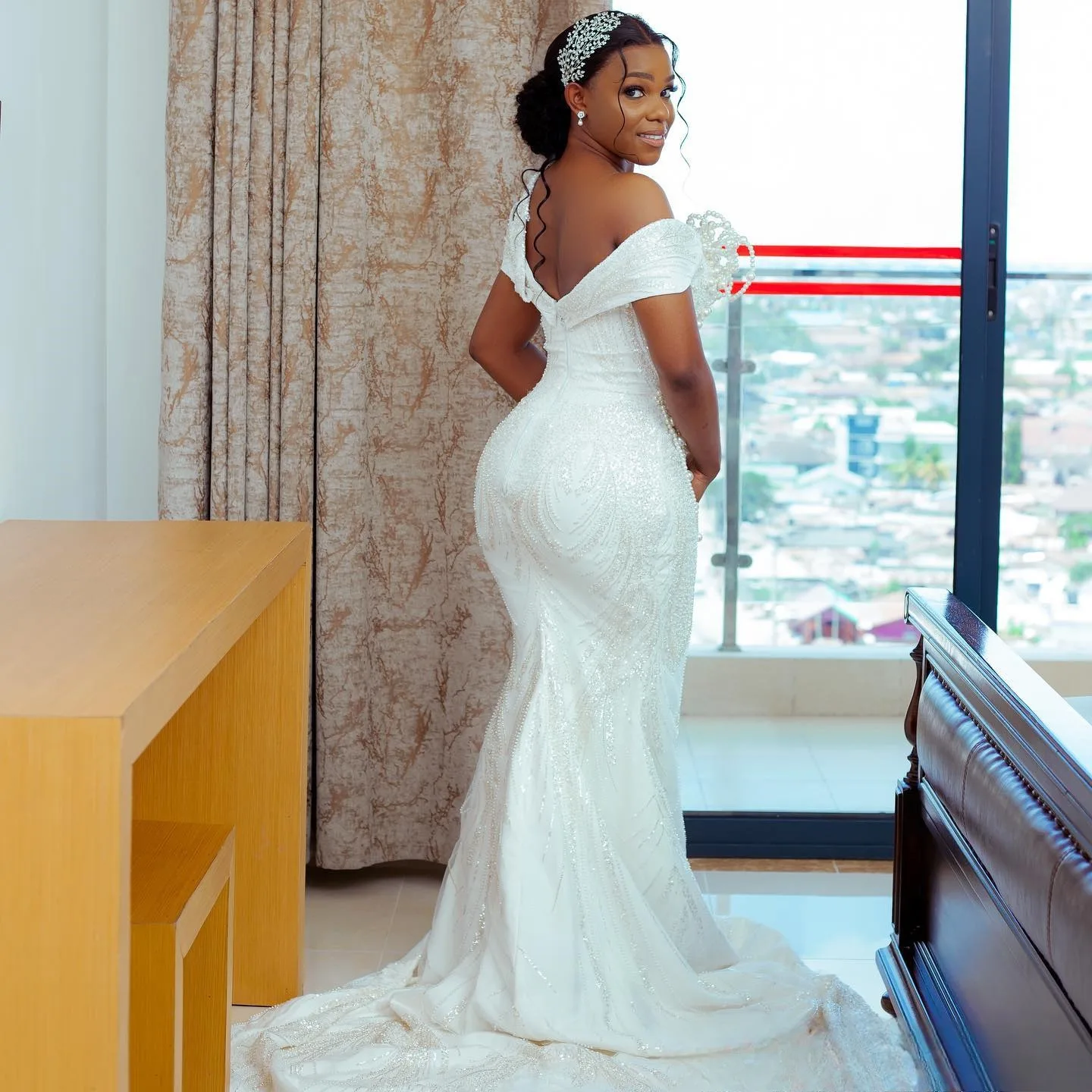 

Индивидуальное свадебное платье с одним открытым плечом, расшитое блестящими крупными жемчужинами, с шлейфом, длинными рукавами и открытой спиной