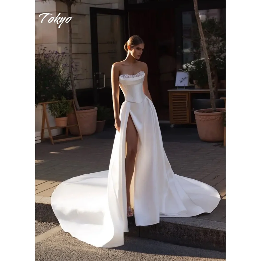 Gaun pengantin Tokyo putih custom, model high split samping, tanpa tali, tanpa lengan, potongan A-line, dengan veil pengantin, ekor court, dan ritsleting belakang.