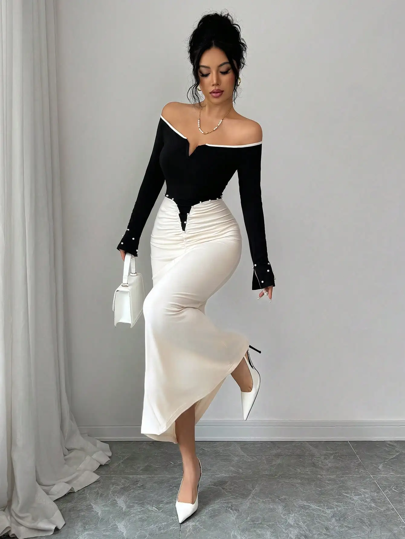 

Черно-кремовое платье с открытыми плечами, длинными рукавами, драпировкой и жемчужной отделкой