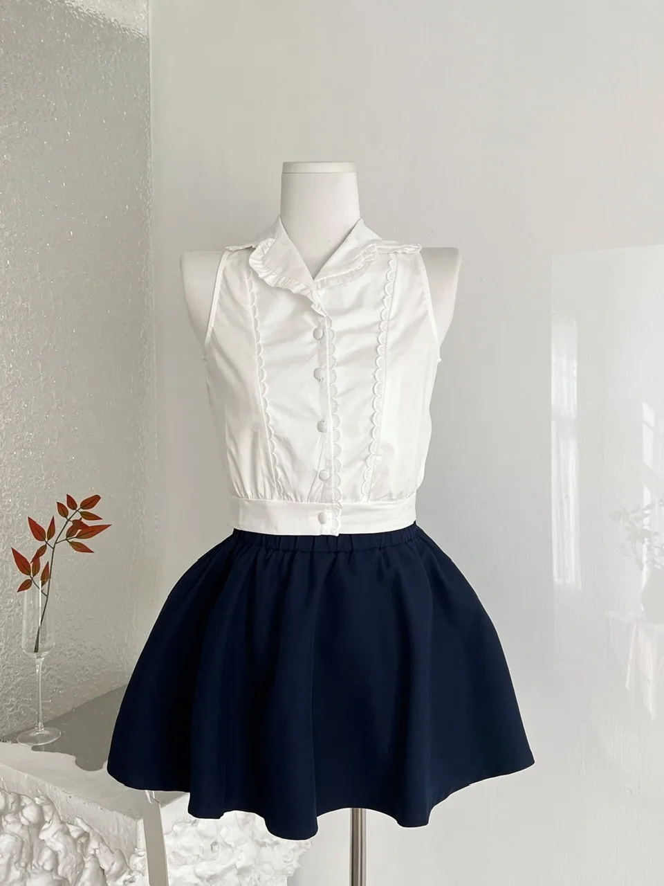 

Летний комплект из двух предметов для похудения: модная женская блузка без рукавов и пышная короткая юбка в студенческом стиле