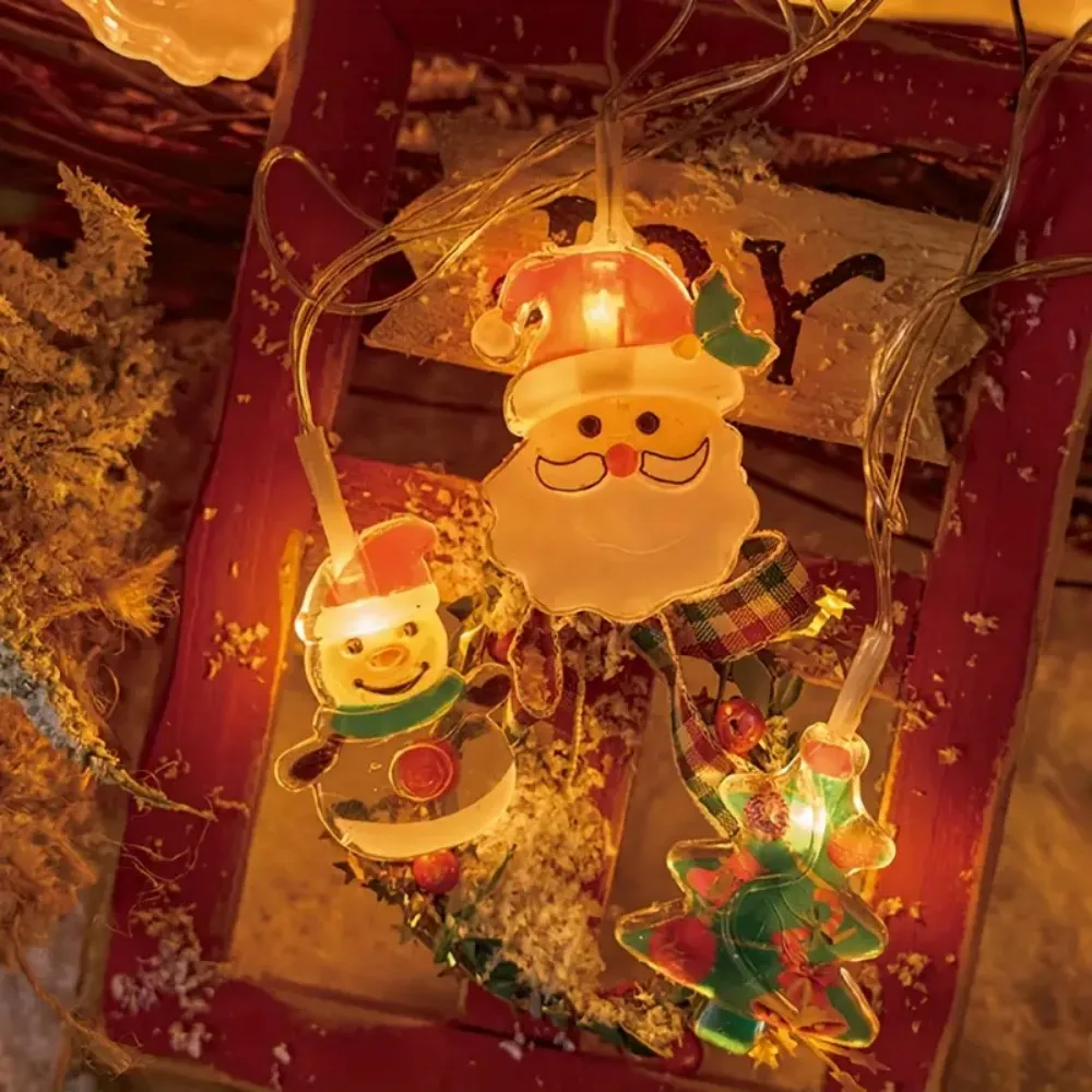 Una cadena de luces LED para las vacaciones navideñas, con diseños de Papá Noel, árbol y muñecos de nieve, funciona con pilas