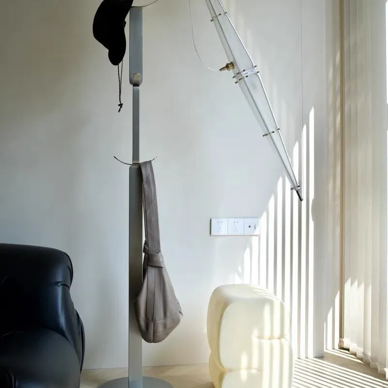 The floor-to-ceiling coat rack is a stainless steel simple modern sculpture-like household hanger.