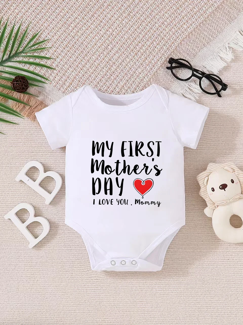 Playful letter-printed baby short-sleeve triangle bodysuit. Button closure for easy dressing, machine washable